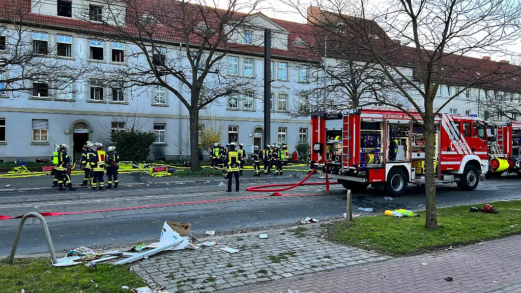 Feuerwehrleute-stehen-vor-einem-Magdeburger-Mehrfamilienhaus