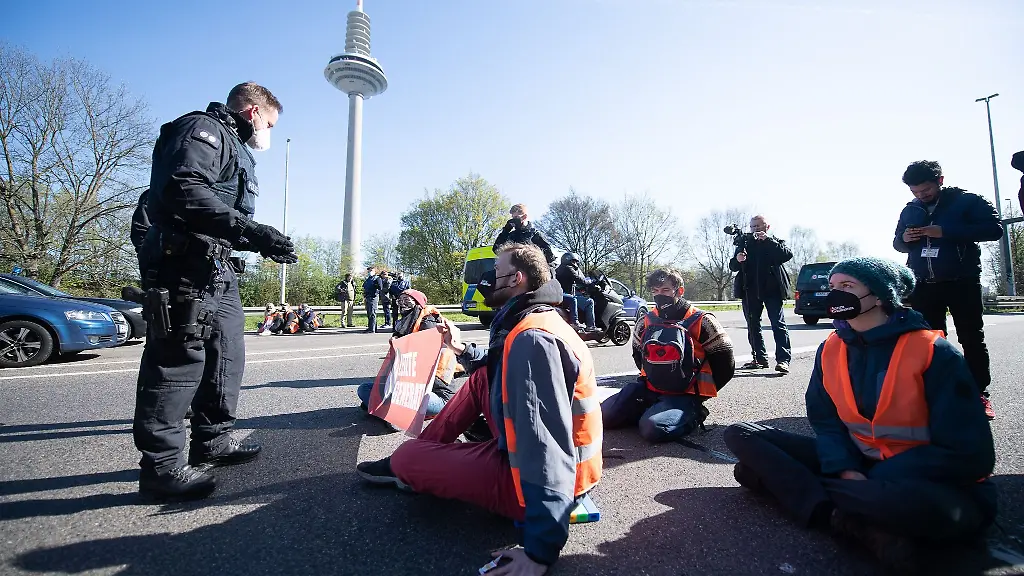 Demonstranten-sitzen-waehrend-einer-Blockadeaktion-auf-der-A66-auf-dem-Boden
