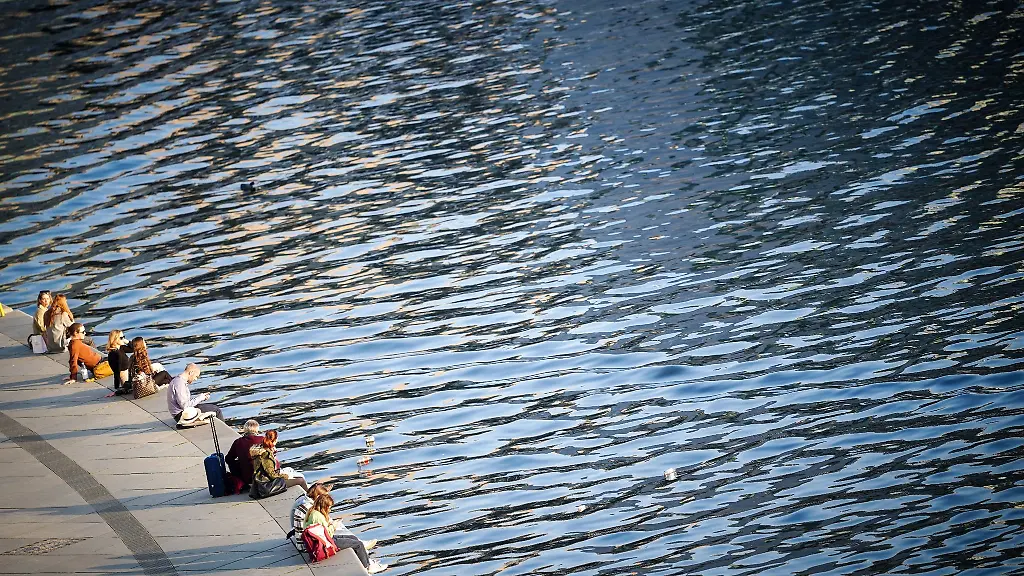 Menschen-geniessen-den-Sonnenschein-am-Spreeufer-im-Regierungsviertel