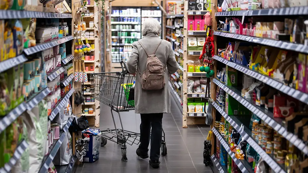 Eine-Frau-geht-mit-ihrem-Einkaufswagen-durch-einen-Supermarkt