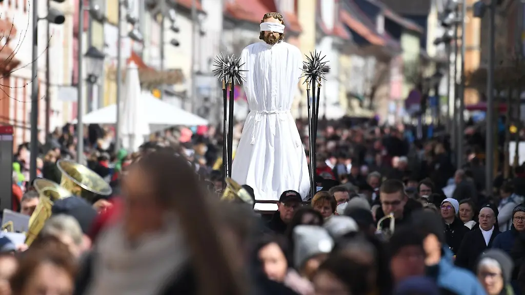 Glaeubige-tragen-bei-der-Palmsonntagsprozession-eine-ueberlebensgrosse-Darstellung-Erniedrigung