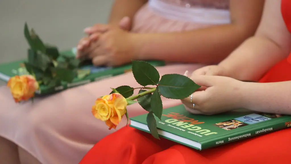 Teilnehmer-einer-Jugendweihefeier-sitzen-auf-ihren-Plaetzen
