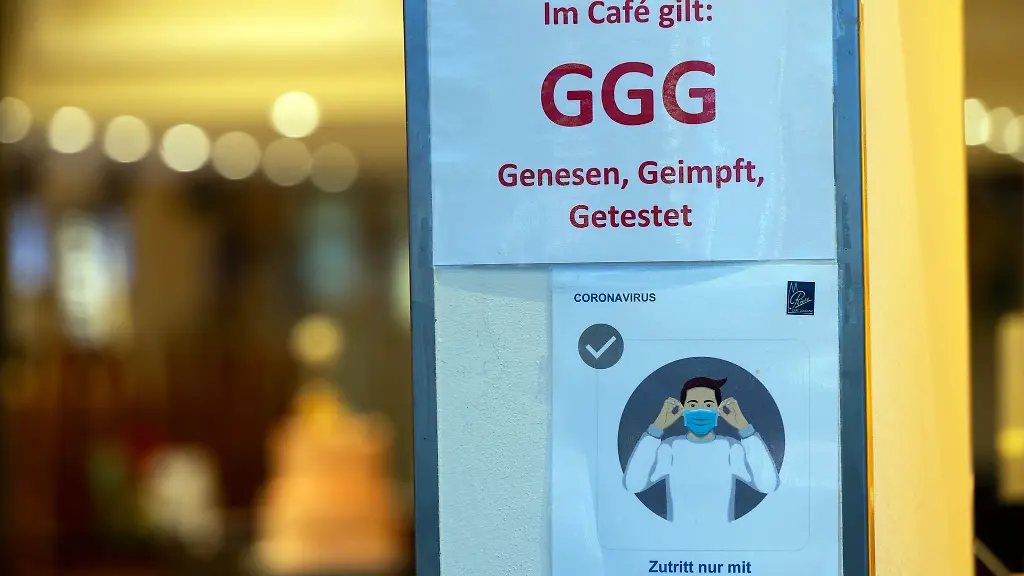 Hinweisschilder-zu-Corona-Schutzmassnahmen-haengen-in-der-Koelner-Innenstadt-am-Eingang-eines-Cafes