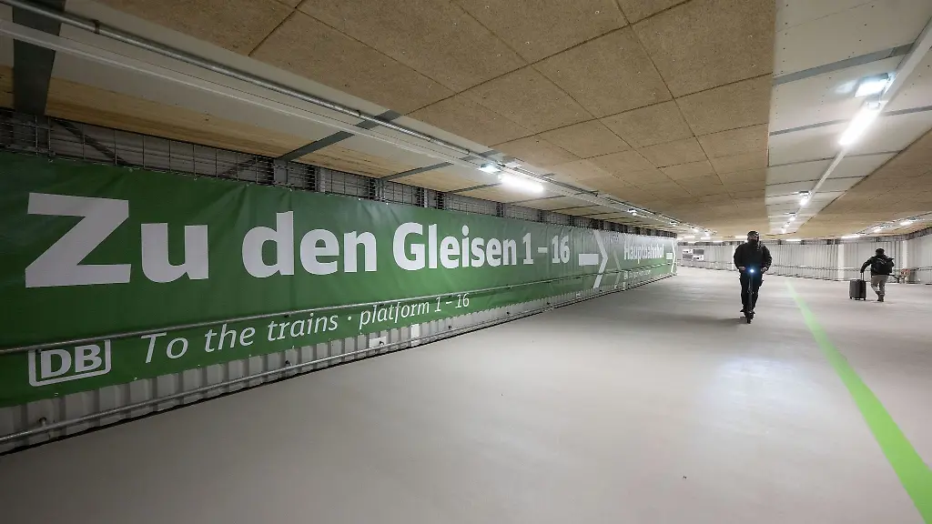 Ein-Banner-weist-in-einem-Steg-am-Hauptbahnhof-auf-dem-Weg-zu-den-Gleisen-hin