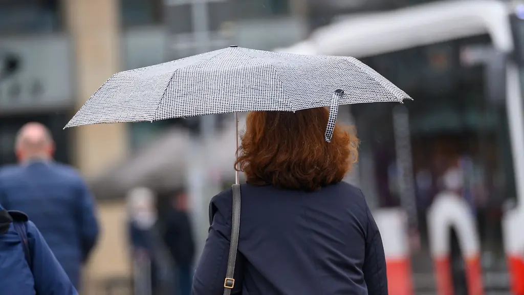 Eine-Passantin-geht-bei-leichtem-Nieselregen-ueber-den-Jungfernstieg