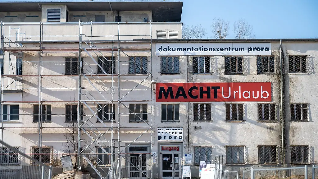 Ein-Schild-mit-der-Aufschrift-MACHT-Urlaub-haengt-an-der-Fassade-des-Dokumentationszentrums-Prora