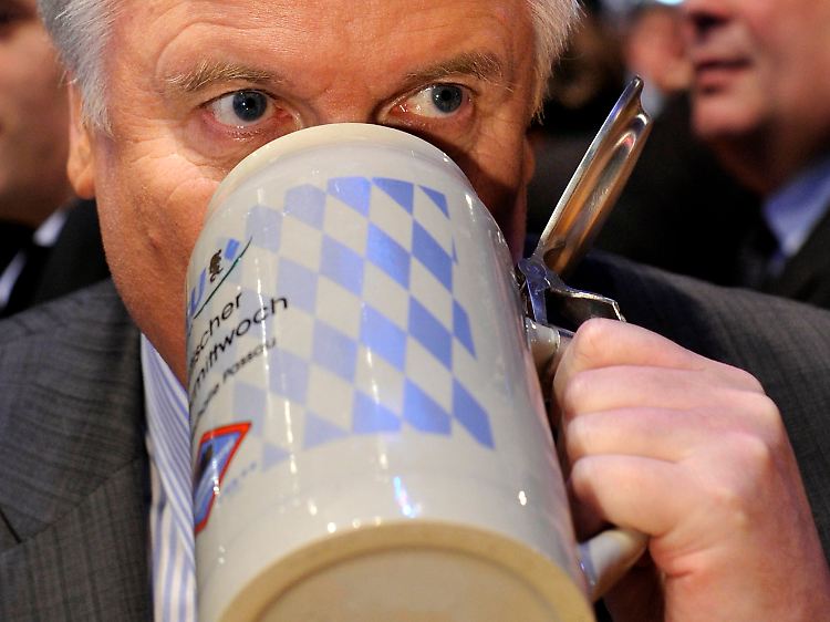 Seehofer schaut in den Humpen.