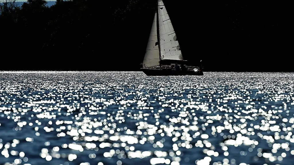 Ein-Segelboot-faehrt-bei-Sonnenschein-ueber-einen-See