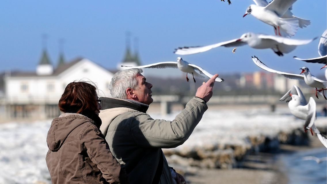 Urlauber im Ostseebad Ahlbeck auf der Insel Usedom vor der historischen Seebrücke.
