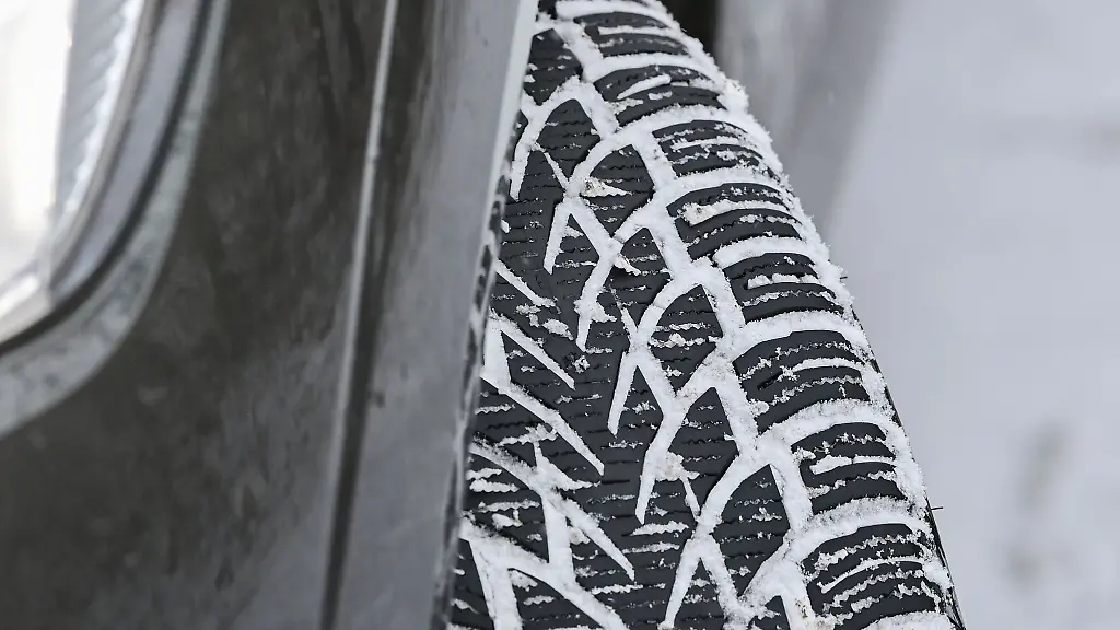 Das-Profil-eines-Winterreifens-auf-einem-Auto-hat-sich-vom-Schnee-auf-der-Fahrbahn-zugesetzt