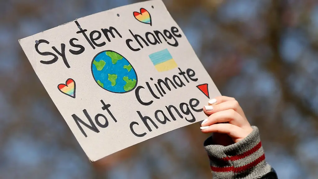 Eine-Demonstrantin-haelt-ein-Schild-mit-der-Aufschrift-System-change-Not-climate-change