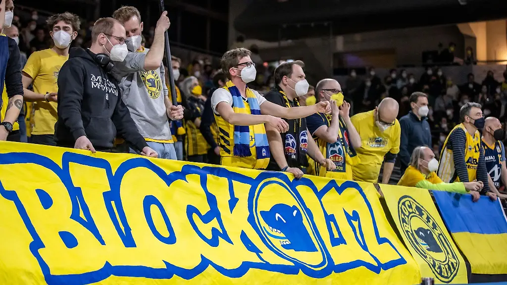 Fans-von-Alba-Berlin-stehen-hinter-einem-Banner-mit-Schriftzug-Block-212