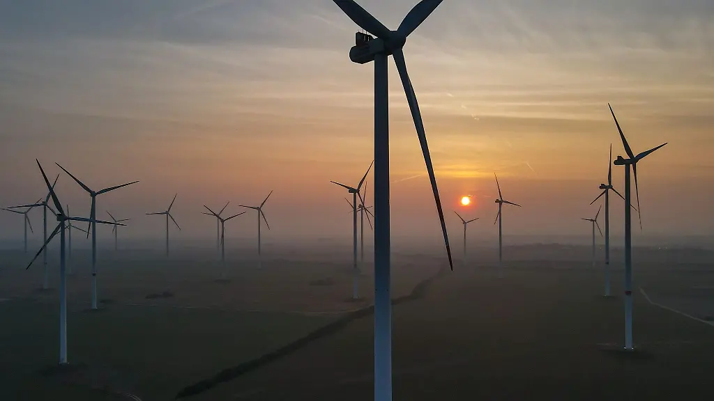 Die-Sonne-geht-hinter-mehreren-Windenergieanlagen-unter