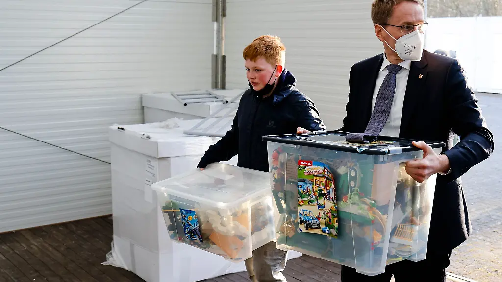 Ministerpraesident-Daniel-Guenther-r-CDU-und-Julius-Paul-tragen-Kisten-mit-Spielsachen-in-ein-Zelt