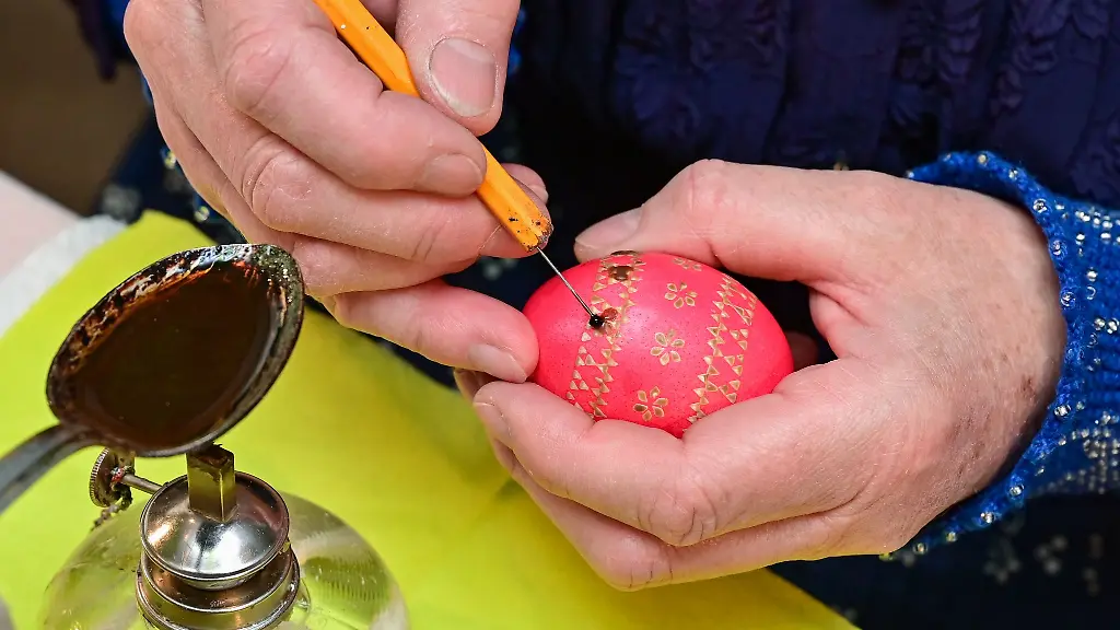 Eine-Frau-verziert-ein-Huehnerei-auf-der-Ostereiermesse-im-Spreewald-Museum