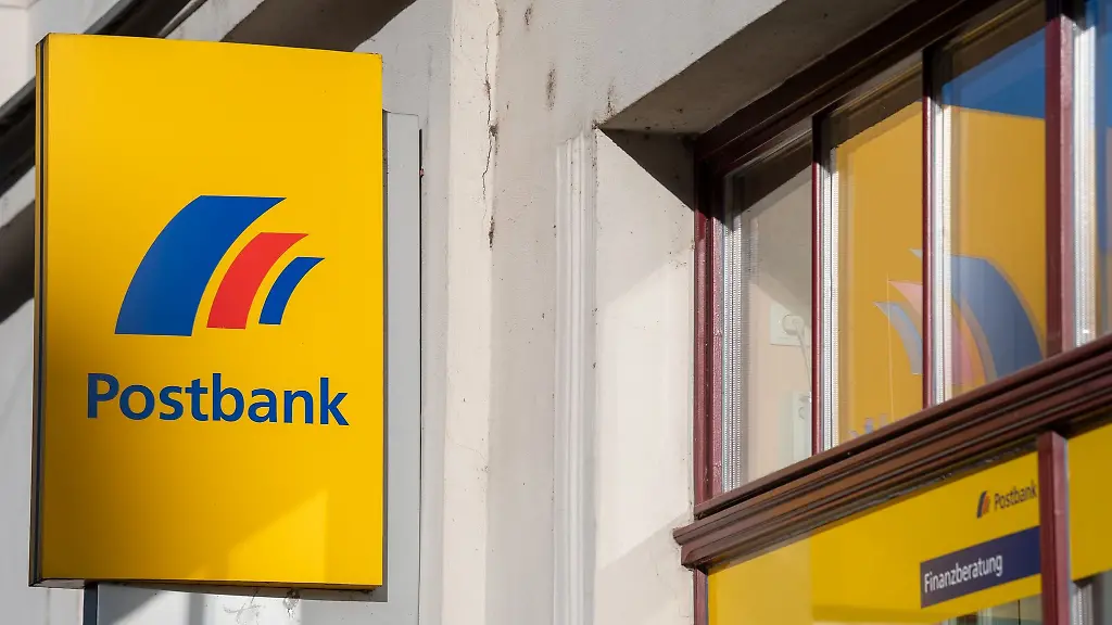 Ein-Schild-mit-dem-Logo-der-Postbank-ist-an-der-Fassade-einer-Bankfiliale-angebracht