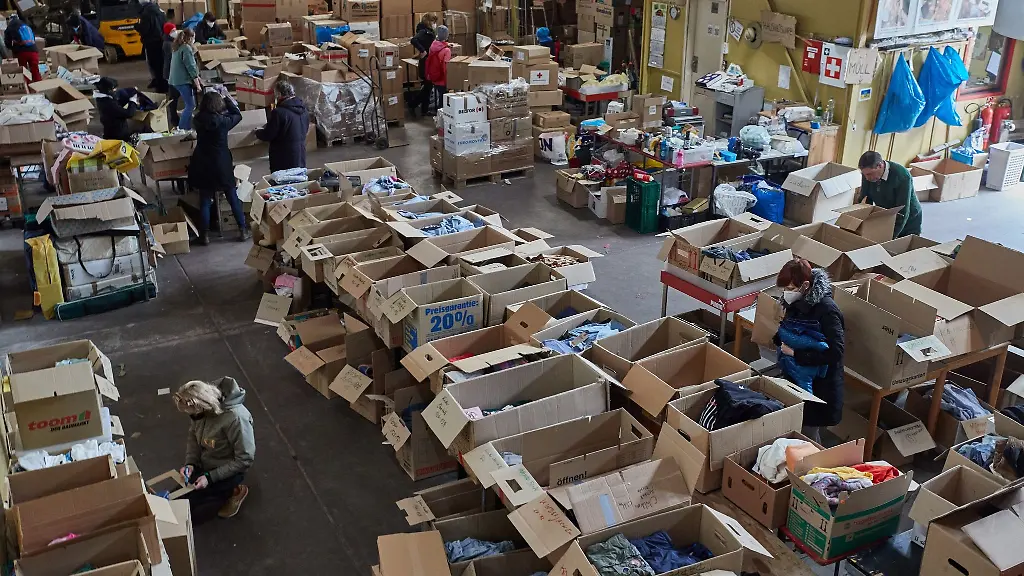 Ehrenamtliche-Helfer-und-ukrainische-Fluechtlinge-sortieren-Spenden-in-der-Kleiderkammer-in-Rissen