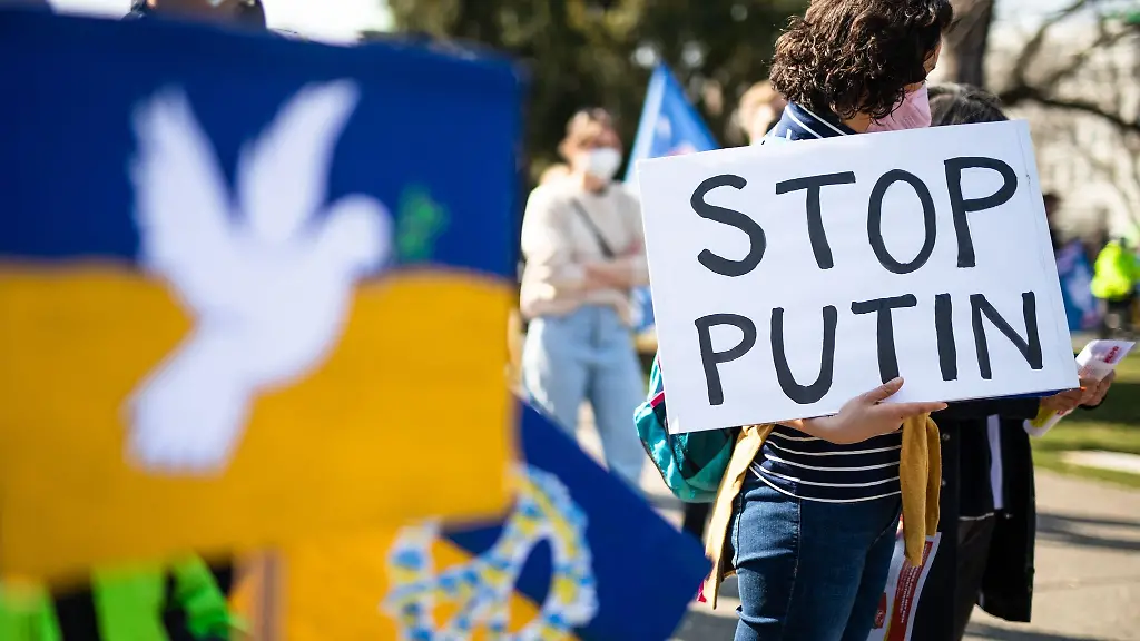 Bei-einer-Demo-im-oberen-Schlossgarten-haelt-eine-Frau-ein-Schild-mit-der-Aufschrift-Stop-Putin