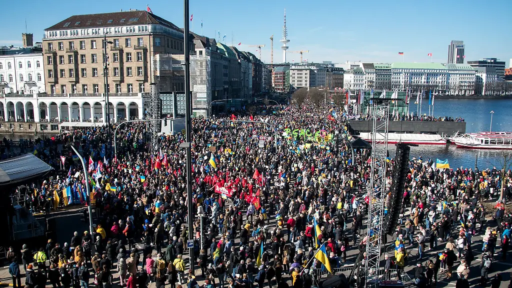 Teilnehmer-einer-Demonstration-gegen-den-Ukraine-Krieg-stehen-auf-dem-Jungfernstieg
