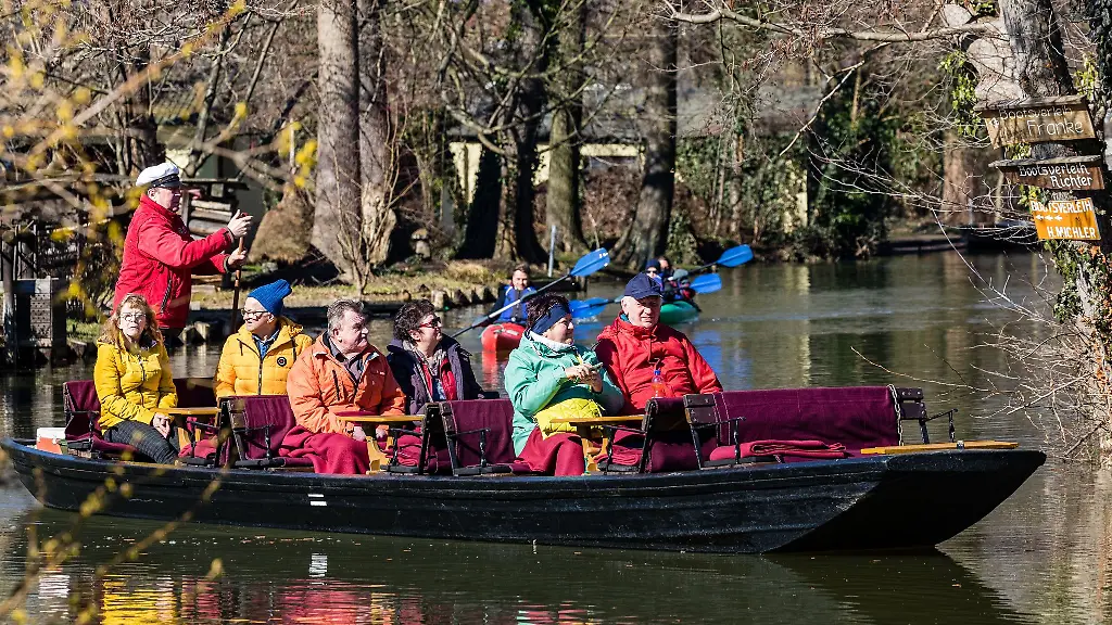 Kahnfaehrmann-stakt-seinen-mit-Besuchern-besetzten-Kahn-durch-die-Spreewaldfliesse-im-Spreewald-bei-Luebbenau