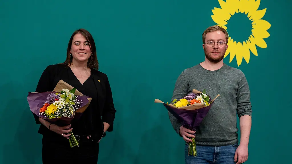 Natalie-Cramme-Hill-l-und-Paul-Bunjes-posieren-mit-Blumenstraeussen-als-neue-Landesvorsitzende