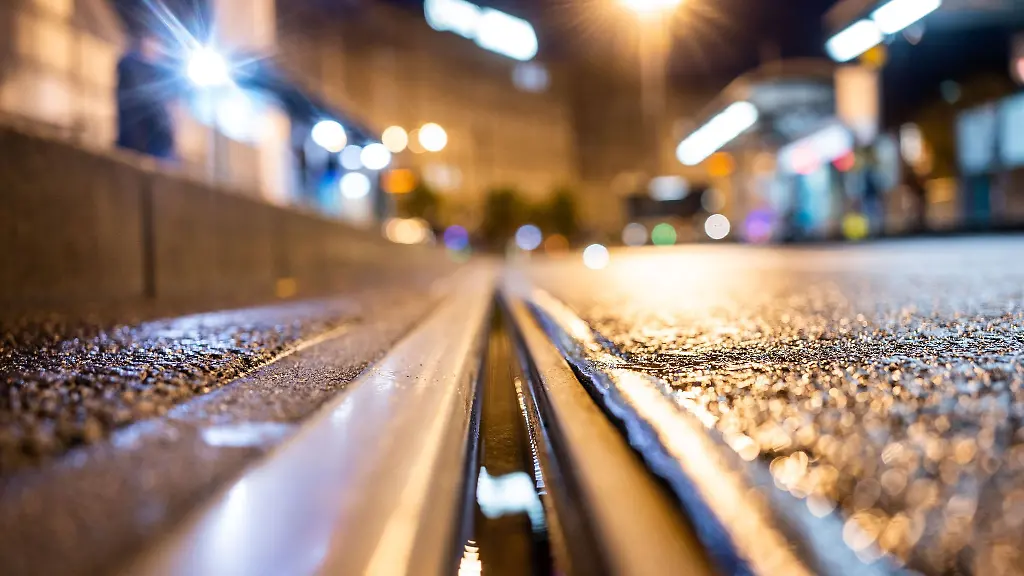 Laternenlicht-faellt-in-Frankfurt-auf-Schienen-der-Strassenbahn
