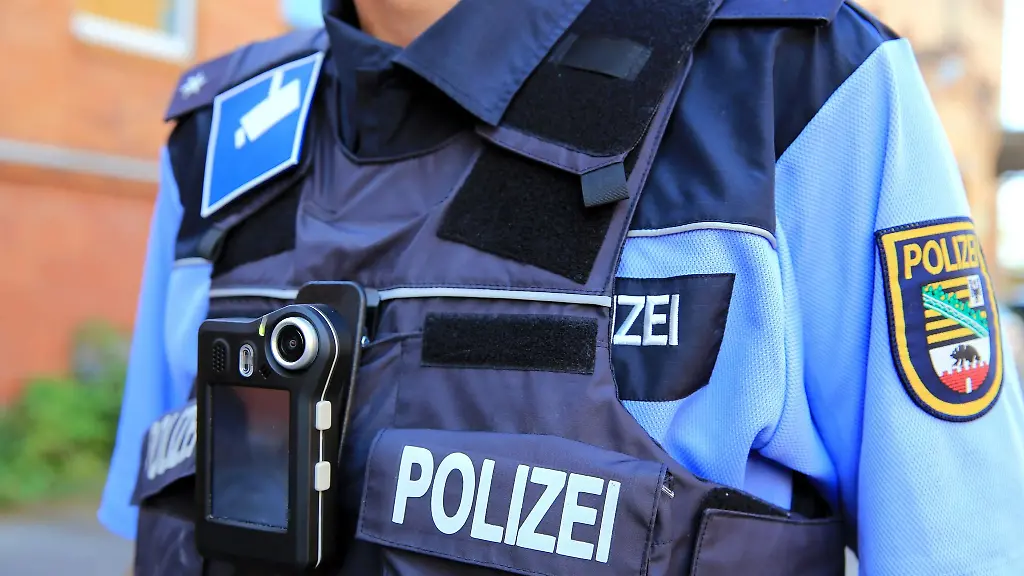 Ein-Polizeikommissar-traegt-eine-mobile-Miniatur-Videokamera-Bodycam-vor-seiner-Brust