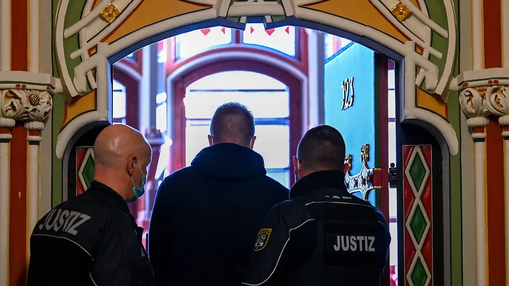 Justizbeamte-fuehren-den-Angeklagten-M-vor-Beginn-des-Prozess-an-seinen-Platz