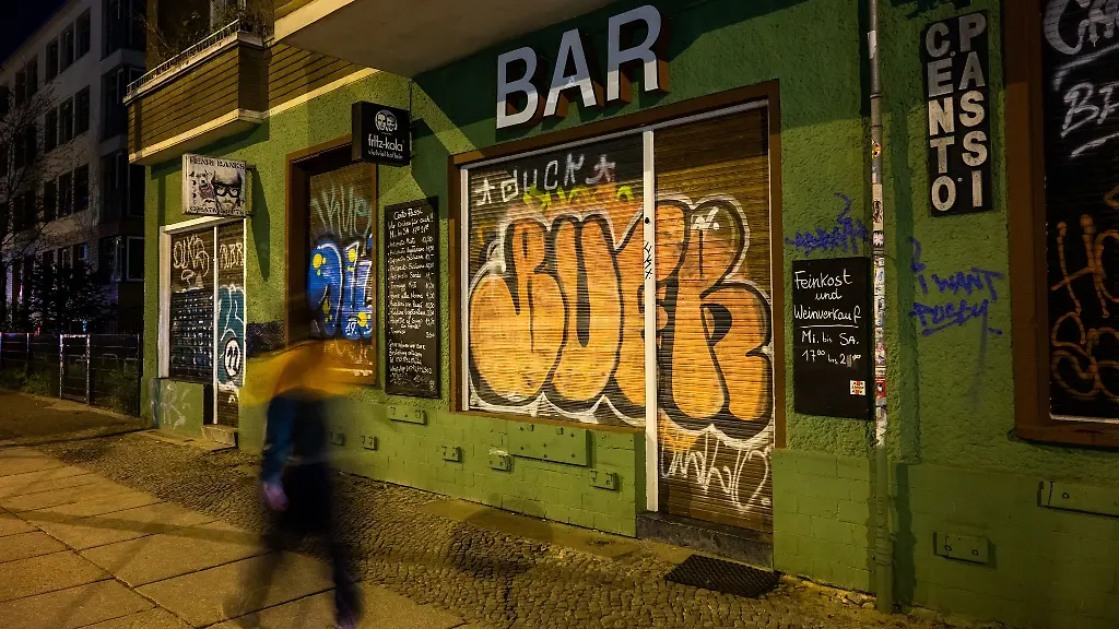 Ein-Mann-geht-an-einer-geschlossenen-Bar-im-Stadtteil-Friedrichshain-vorbei