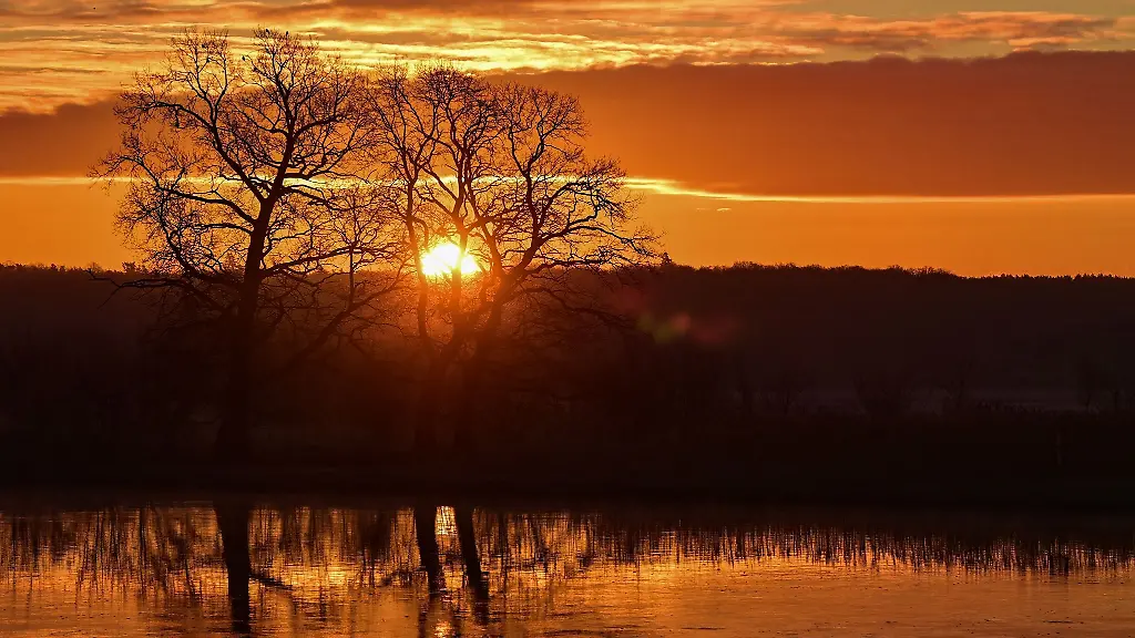 Die-aufgehende-Sonne-leuchtet-am-Himmel-hinter-dem-deutsch-polnischen-Grenzfluss-Oder
