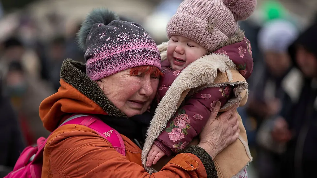 Eine-weinende-Frau-mit-einem-Kind-im-Arm-am-Grenzuebergang-im-polnischen-Medyka