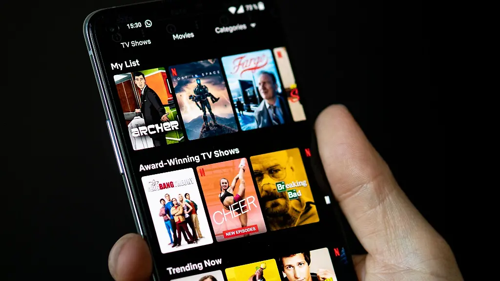 Auf-dem-Bildschirm-eines-Smartphones-sieht-man-in-der-App-von-Netflix-das-Filmangebot-des-Streaminganbieters
