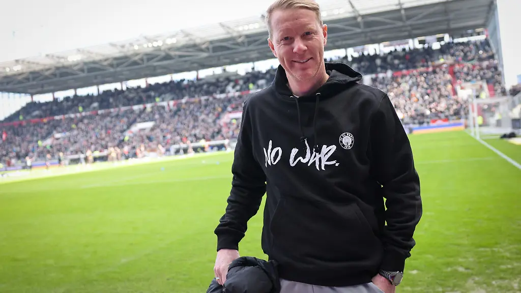 Sankt-Paulis-Trainer-Timo-Schultz-traegt-einen-Pullover-mit-dem-Text-No-War