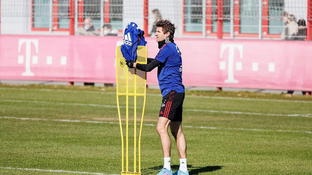 Thomas-Mueller-vom-FC-Bayern-Muenchen-haengt-ein-Leibchen-auf-einen-Aufsteller