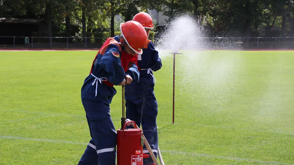 Zwei-Mitglieder-einer-Thueringer-Jugendfeuerwehr-ueben-mit-einer-Kuebelspritze