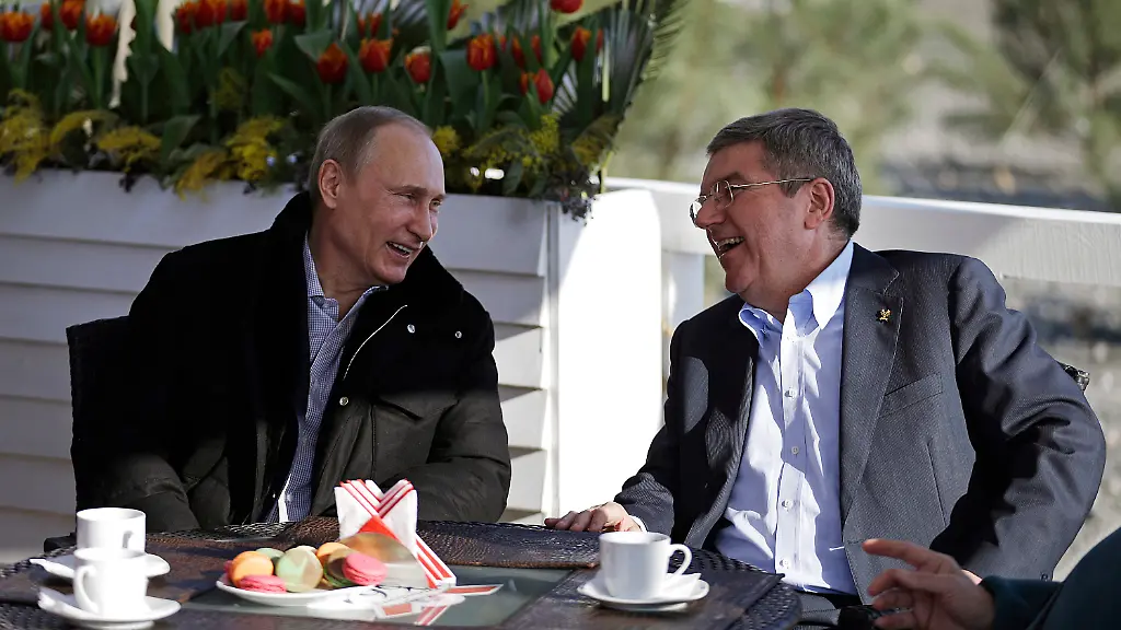 Der-russische-Praesident-Wladimir-Putin-l-und-der-IOC-Praesident-Thomas-Bach-unterhalten-sich-waehrend-der-Olympischen-Spiele-2014-in-Sotschi