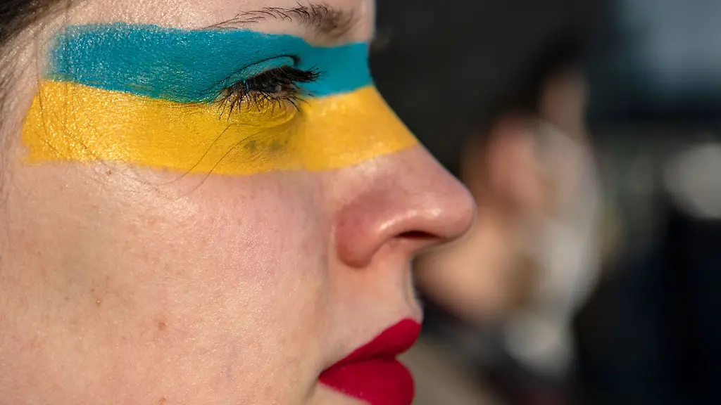 Die-Teilnehmerin-einer-Demonstration-hat-sich-Unterstuetzung-fuer-die-Ukraine-jetzt-ins-Gesicht-gemalt
