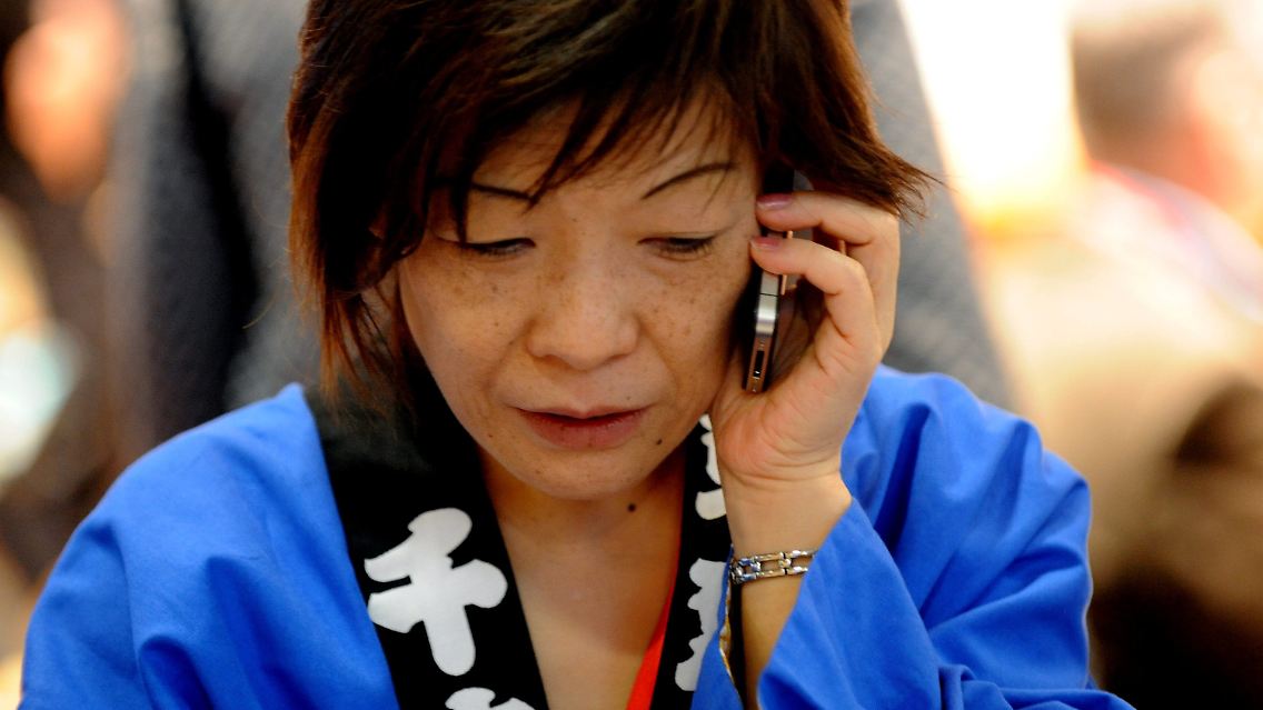 Voller Sorge: Eine japanische Mitarbeiterin versucht in Berlin auf der ITB nach Japan zu telefonieren.