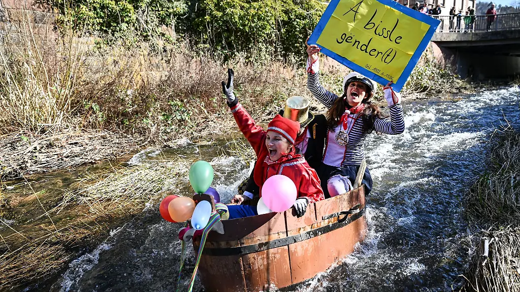 Narren-fahren-bei-der-inoffiziellen-Da-Bach-na-Fahrt-in-geschmueckten-Holzzubern-die-Schiltach-hinunter