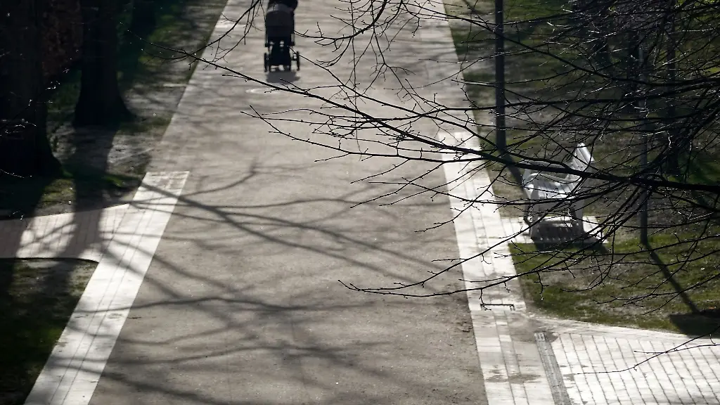 Eine-Frau-geht-bei-Sonnenschein-durch-den-Schlossgarten-in-Kiel