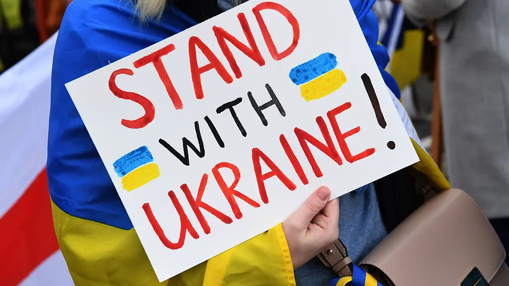 Eine-Demonstrantin-steht-mit-einem-Plakat-Stand-with-Ukraine-steht-bei-einer-Demo-fuer-die-Ukraine