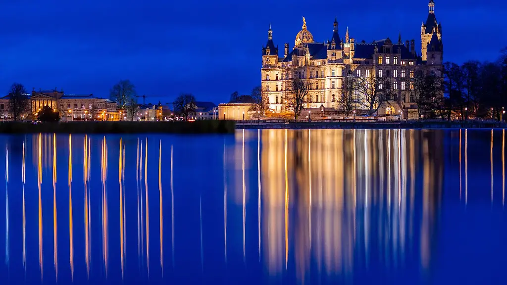 Das-Schweriner-Schloss-spiegelt-sich-am-Abend-im-Wasser-des-Burgsees