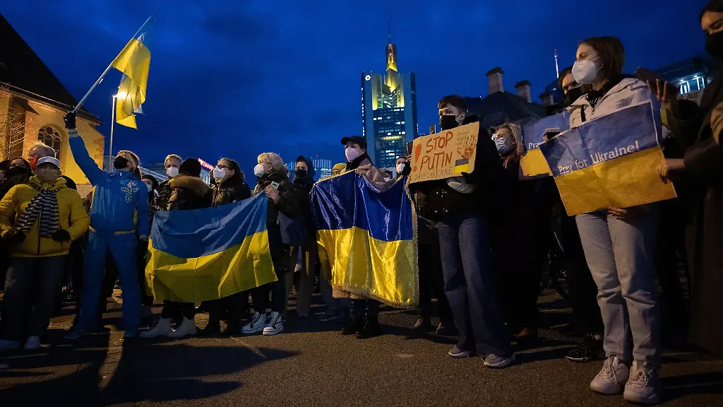 Demonstrierende-tragen-waehrend-einer-Demonstration-Farben-und-Fahnen-der-Ukraine