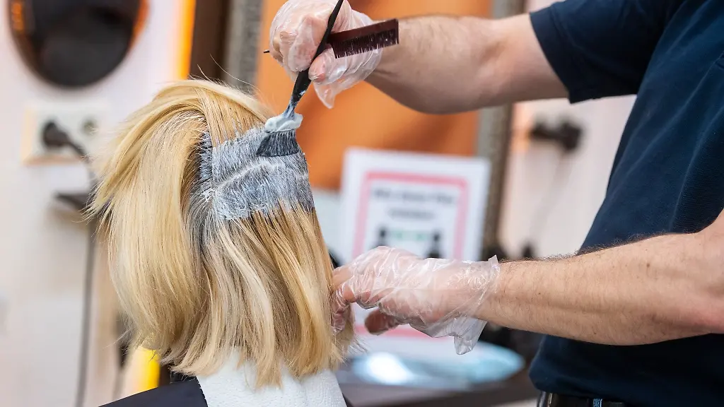 Ein-Friseur-faerbt-einer-Kundin-die-Haare