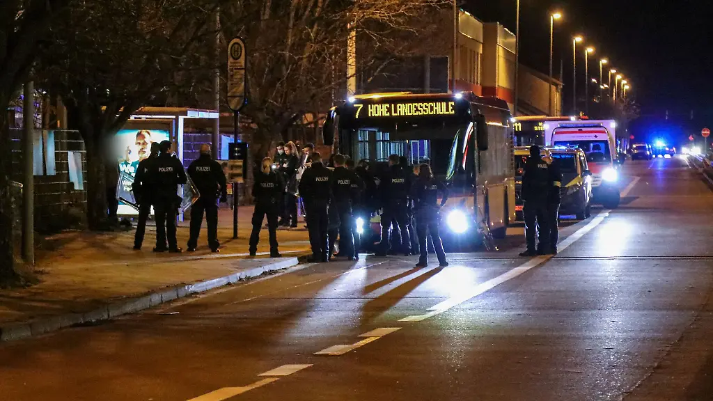 Polizisten-stehen-neben-einem-Bus