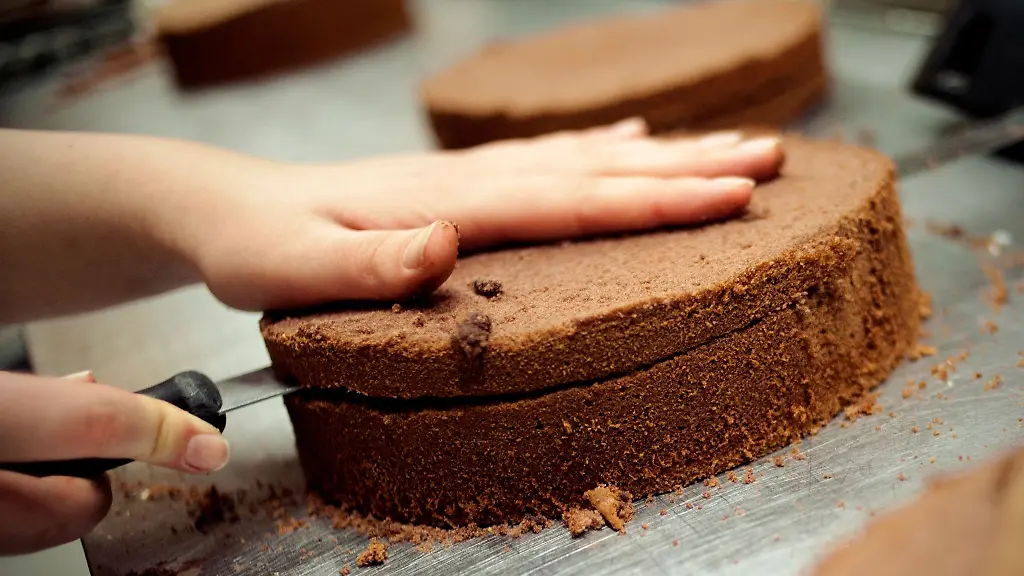 Eine-angehende-Konditorin-schneidet-einen-Kuchenboden-durch