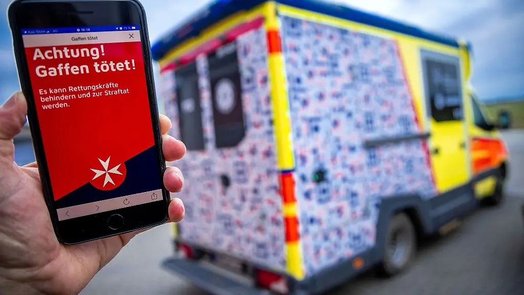 Auf-einem-Smartphone-wird-durch-den-auf-einem-Rettungsfahrzeug-geklebten-QR-Code-der-Warnhinweis-Achtung-Gaffen-toetet-angezeigt