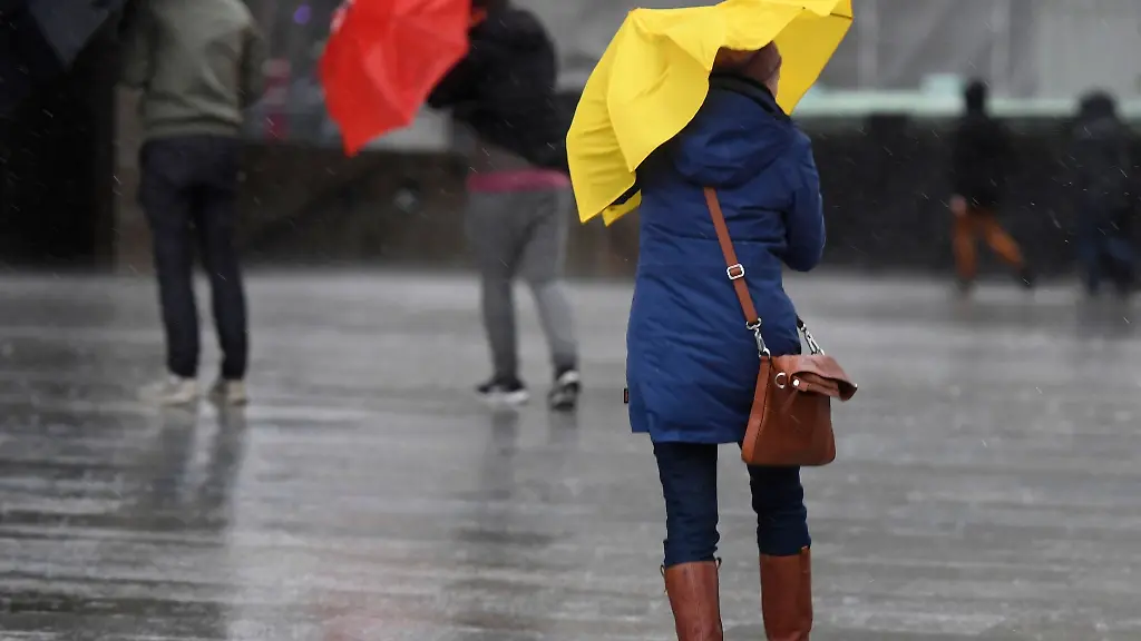 Eine-Fussgaengerin-kaempft-auf-dem-Domvorplatz-in-Koeln-gegen-Regen-und-Wind