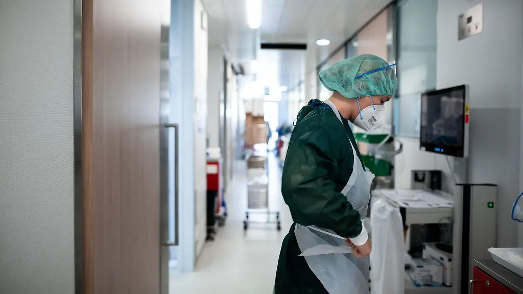 Eine-Mitarbeiterin-der-Pflege-steht-auf-dem-Gang-der-Corona-Intensivstation-des-Universitaetsklinikums-Essen