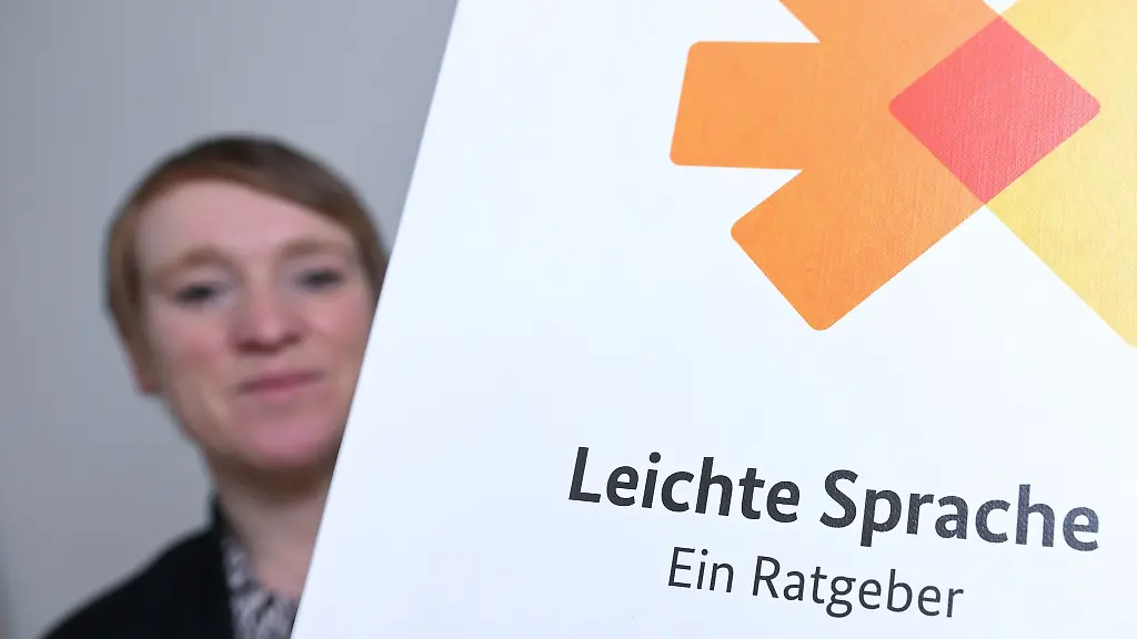 Simone-Fischer-die-Behindertenbeauftragte-des-Landes-Baden-Wuerttemberg-sitzt-in-ihrem-Buero-neben-einer-Broschuere-zum-Thema-leichte-Sprache